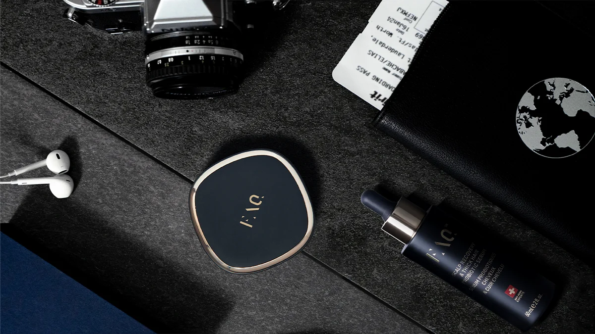 Black FAQ 302 laser hair therapy device on a dark background of a modern desk